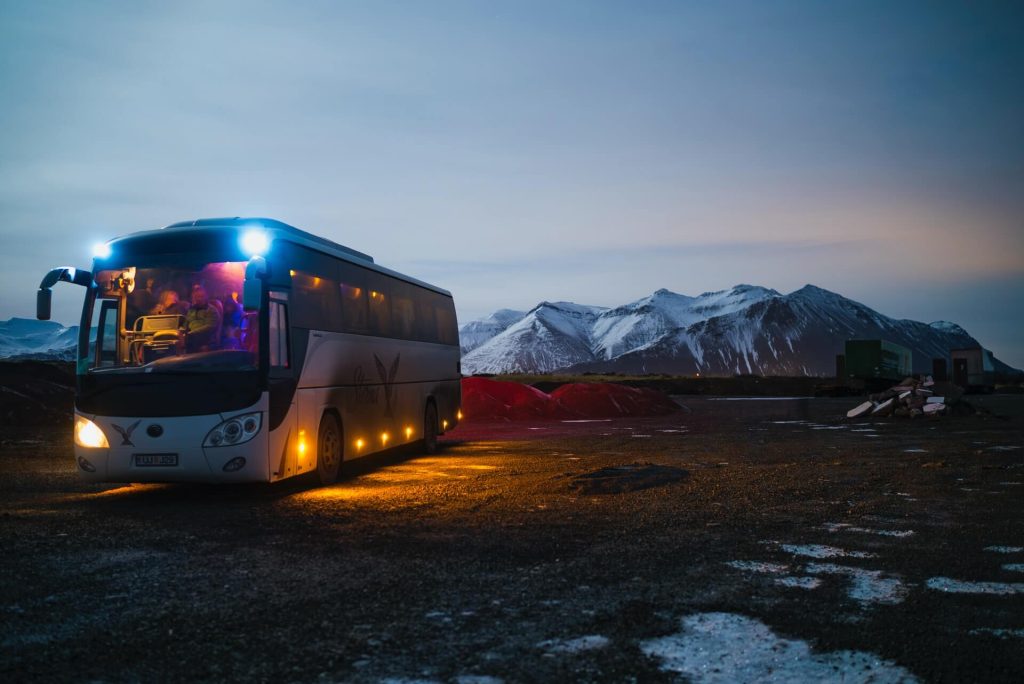 bus parked at sunset by mountains