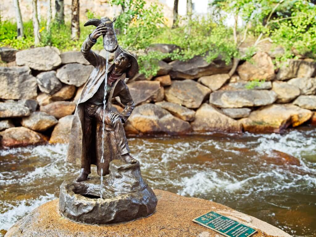 Wishful Thinking Statue. A brass statue of a cowboy emptying water from his boot.